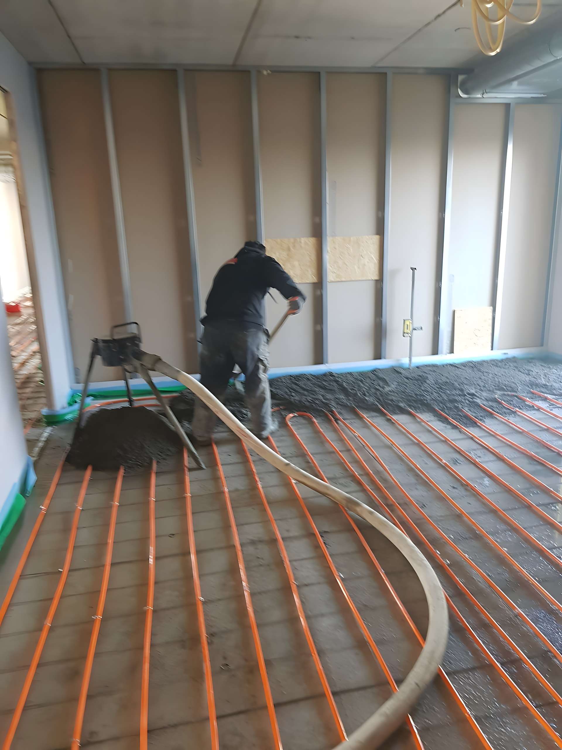 Vloerverwarmingsslangen worden ingegoten in zandcement