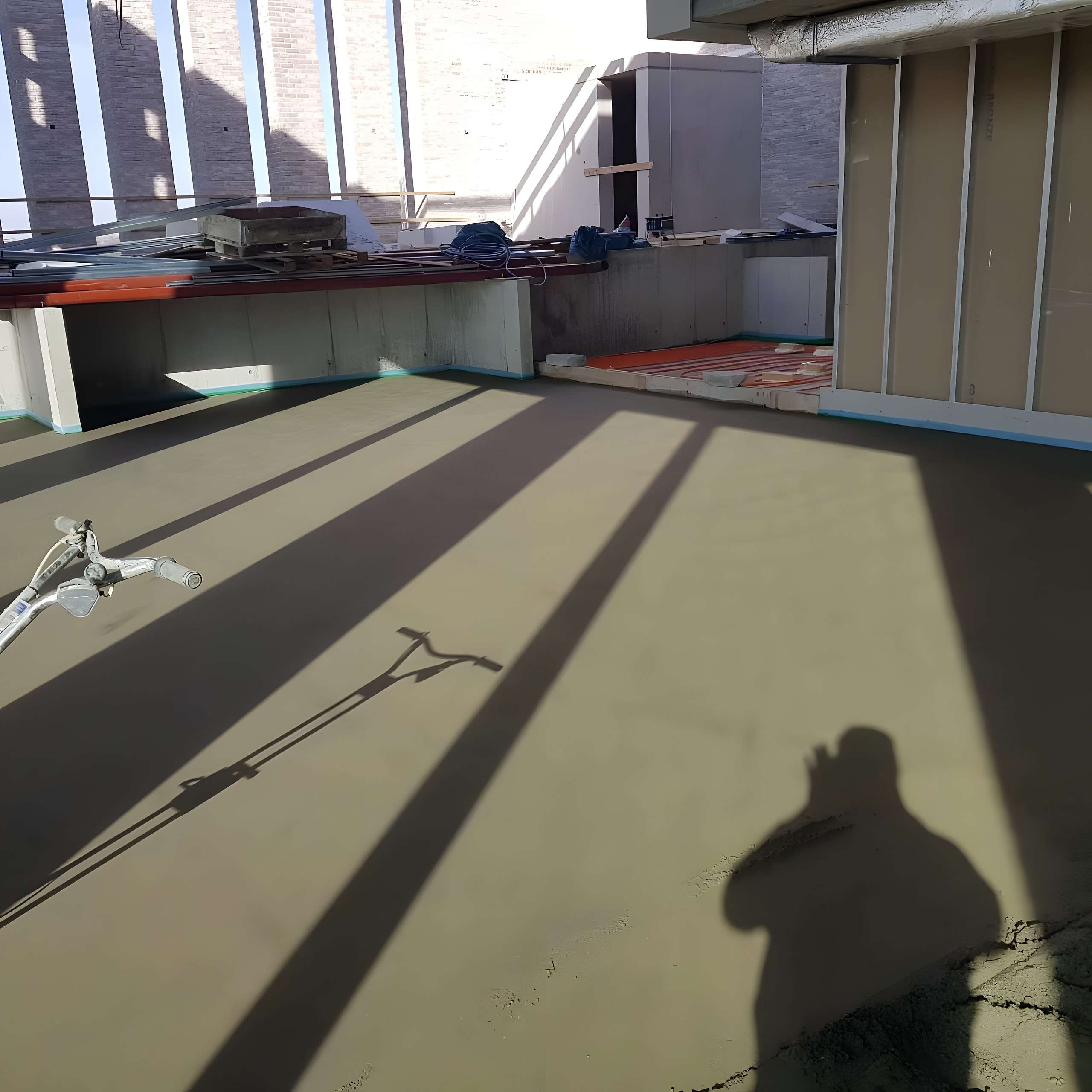 Dekvloer in aanbouw in een pand met grote ramen